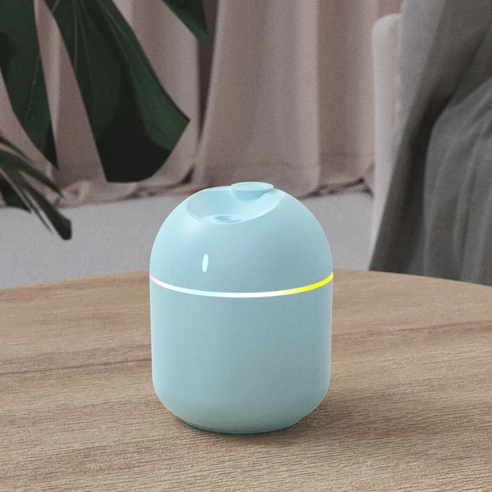 Humidificateur d’air cylindrique gris avec lumière d’ambiance et diffusion continue de brume.